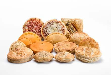 Una variedad de pasteles están colocados uno encima del otro sobre una superficie blanca.