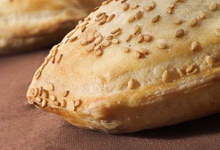 Un primer plano de un pastel con semillas de sésamo sobre una mesa.