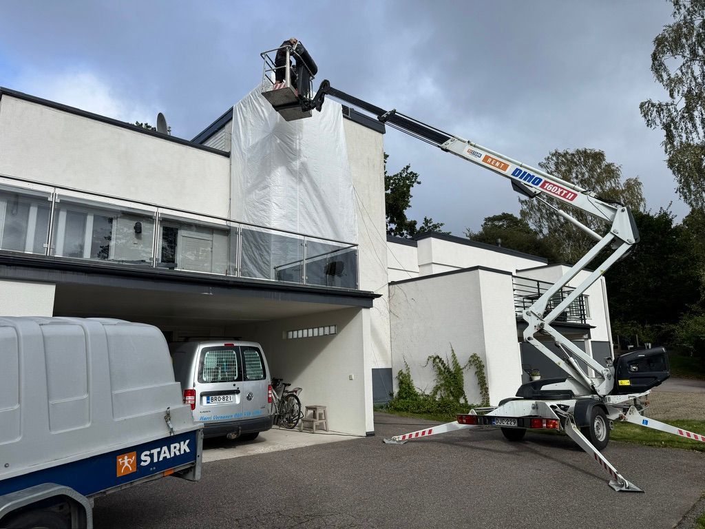 Omakotitalon julkisivun huputus ja suojaus remontissa.