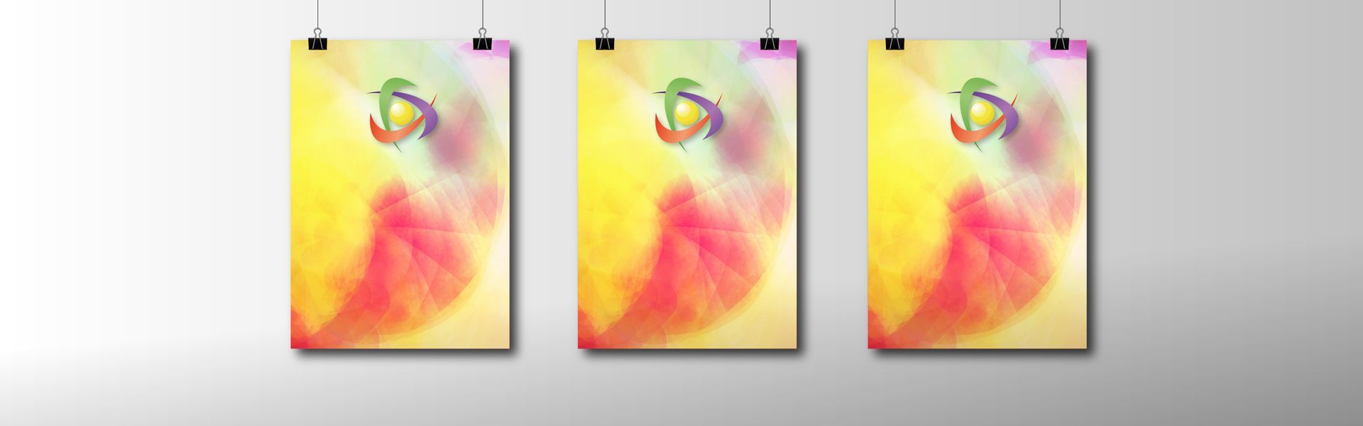 Drei Poster mit farbenfrohen abstrakten Motiven hängen an einer Wand, befestigt an Drähten.