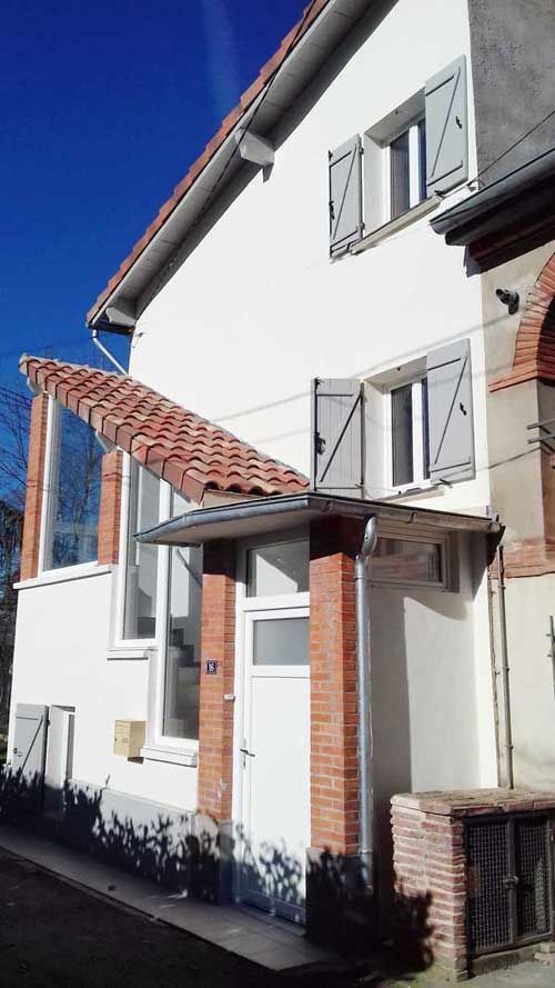 Maison avec montée d'escalier extérieur après le ravalement de façade et peinture des volets