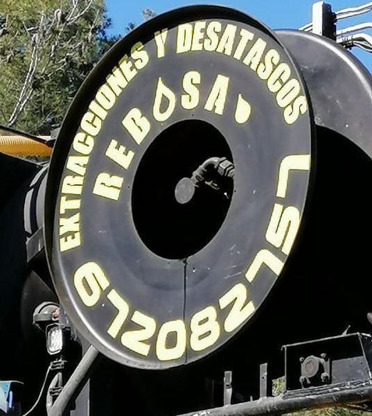 Un gran cartel negro que dice desatascos rebosa