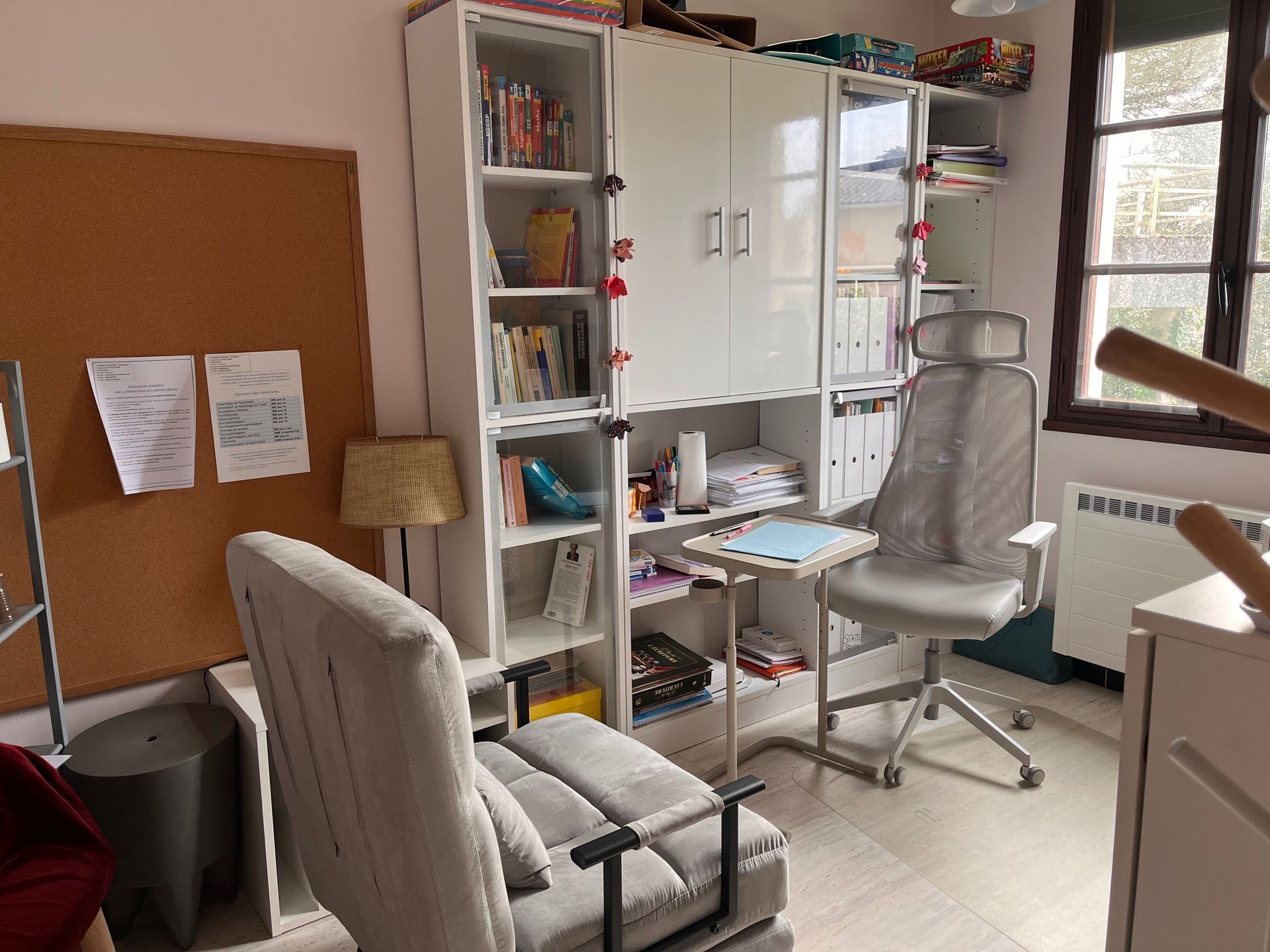 Un canapé beige avec des coussins décoratifs et une boîte de mouchoirs sur une petite table d'appoint dans une pièce avec un tableau au mur.