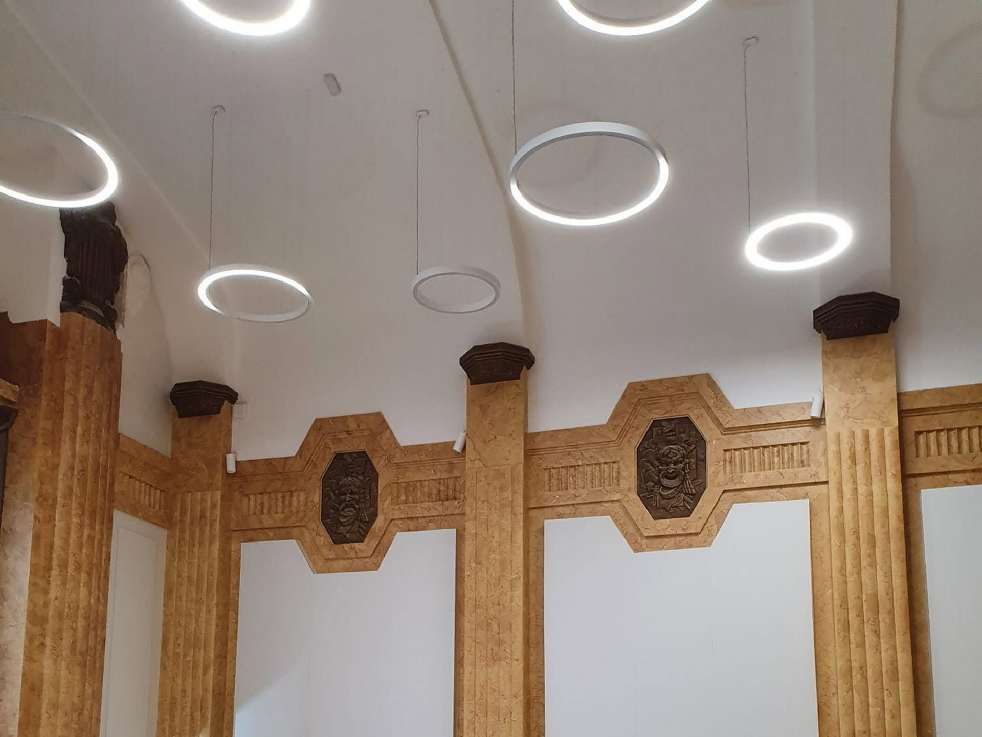 Plafond intérieur du casino de Saint-Quentin, orné de spots circulaires. Les murs sont habillés de colonnes en bois sculpté.