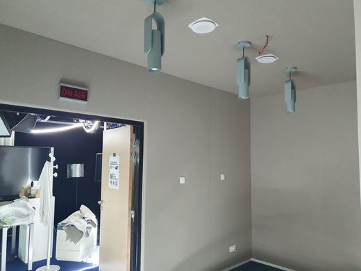 Pièce de studio avec un revêtement acoustique en tissu tendu sur les murs et le plafond.