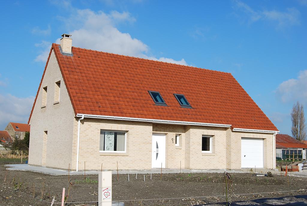 Maison individuelle avec toit en tuile rouge équipée de deux fenêtres Velux à l'avant