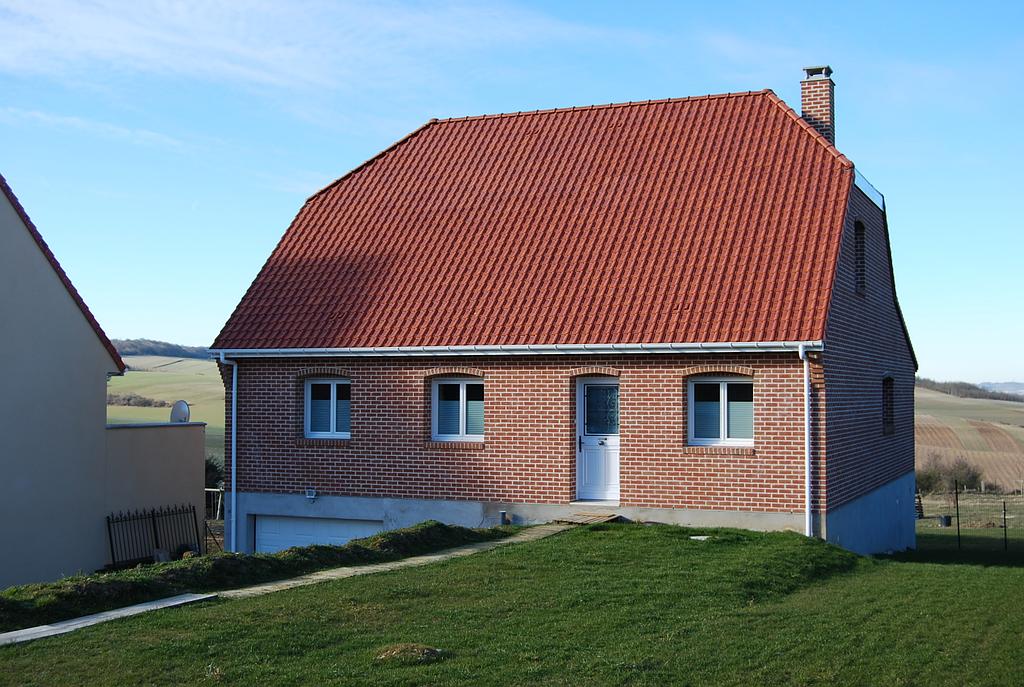 Maison individuelle en brique rouge avec garage en sous-niveau