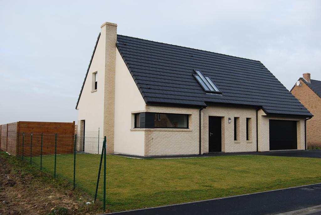 Maison individuelle neuve et moderne équipée d'une cheminée et de fenêtres Velux design