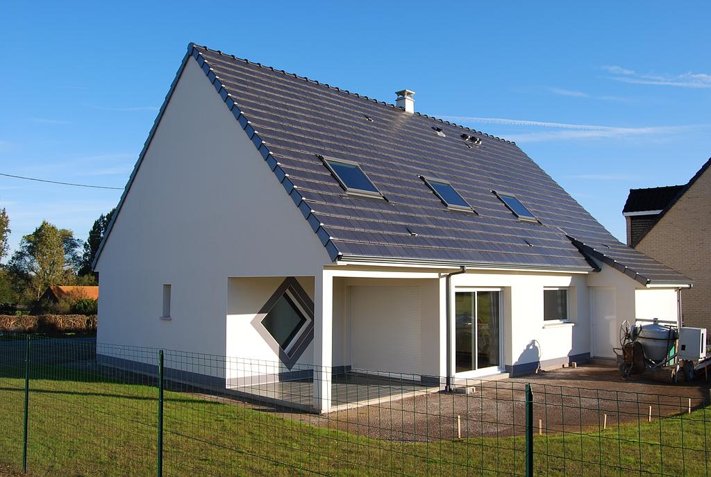 Maison d'un lotissement avec terrasse carrelée abrité par le toit de la maison
