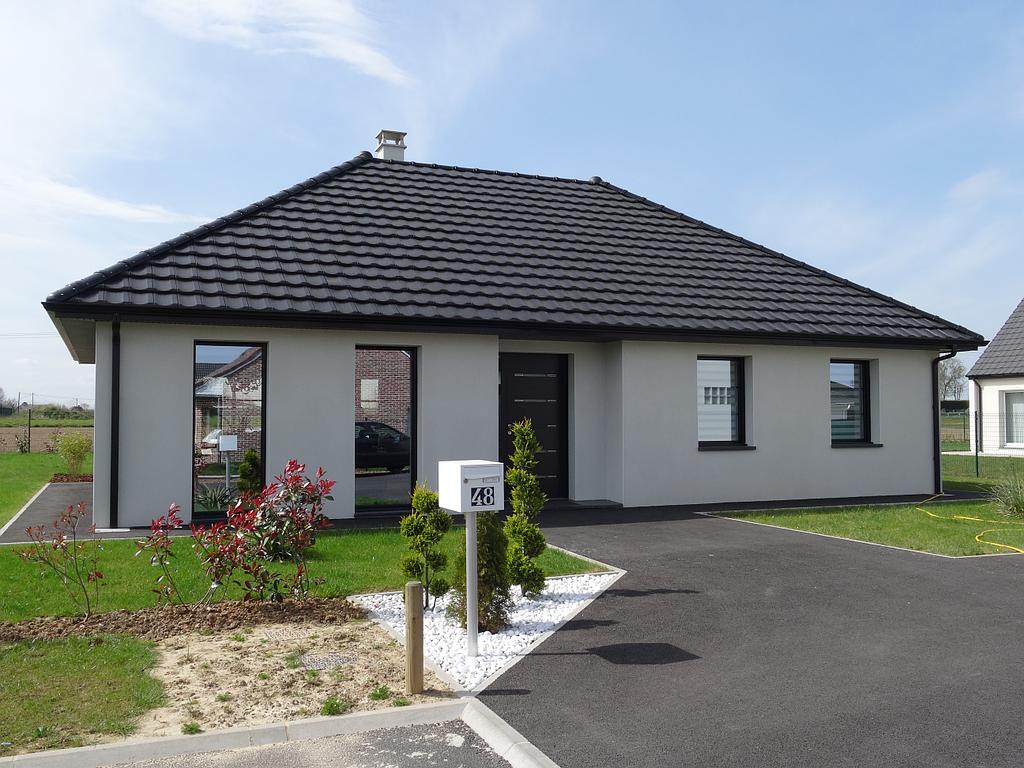 Maison individuelle moderne avec façade en crépi blanc, la boître lettre possède le numéro 48.