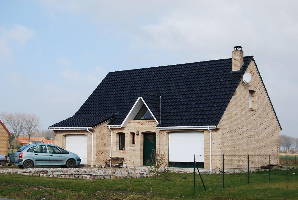 Maison individuelle sur un terrain privé possédant une porte de garage de chaque côté de la maison