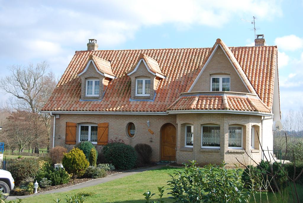 Maison individuelle classique avec une pièce à vivre en forme de tour de château, donnant un balcon au 1er étage