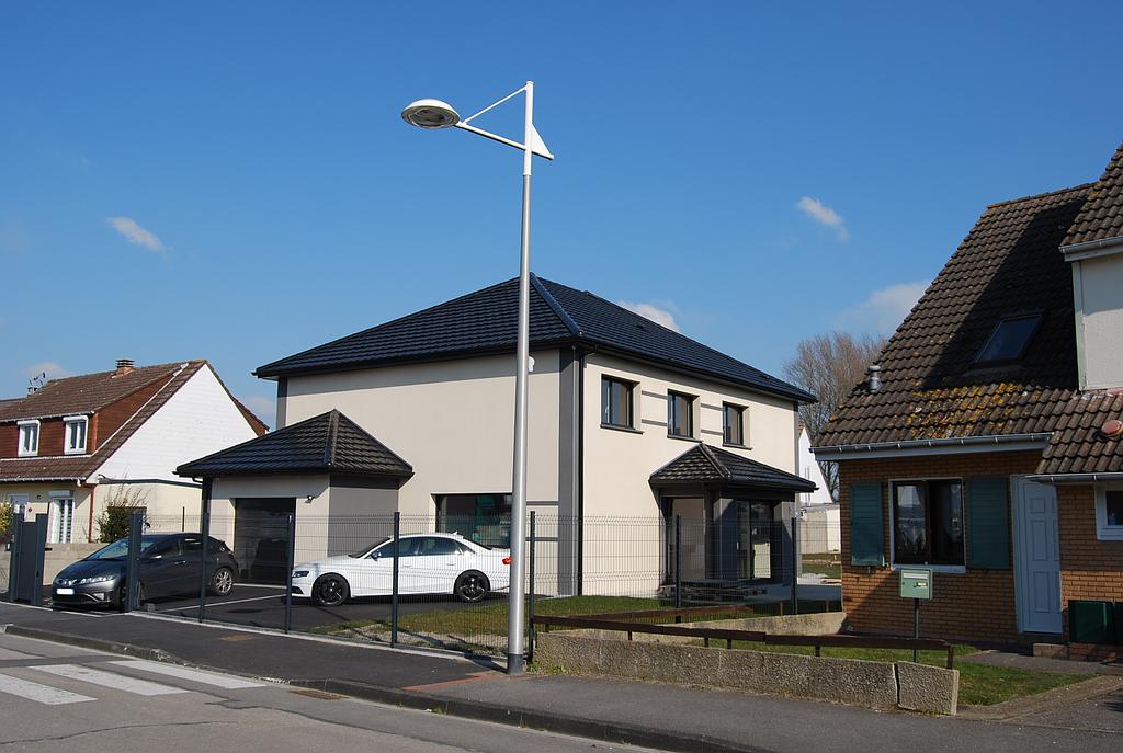 Maison individuelle en crépi blanc possédant une entrée entièrement vitrée