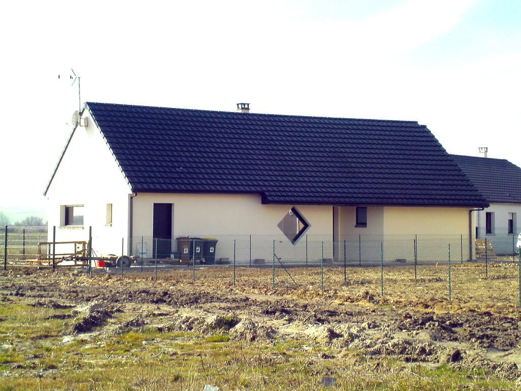 Vue l'avant de la maison individuelle neuve dont le terrain n'est pas encore aménagé