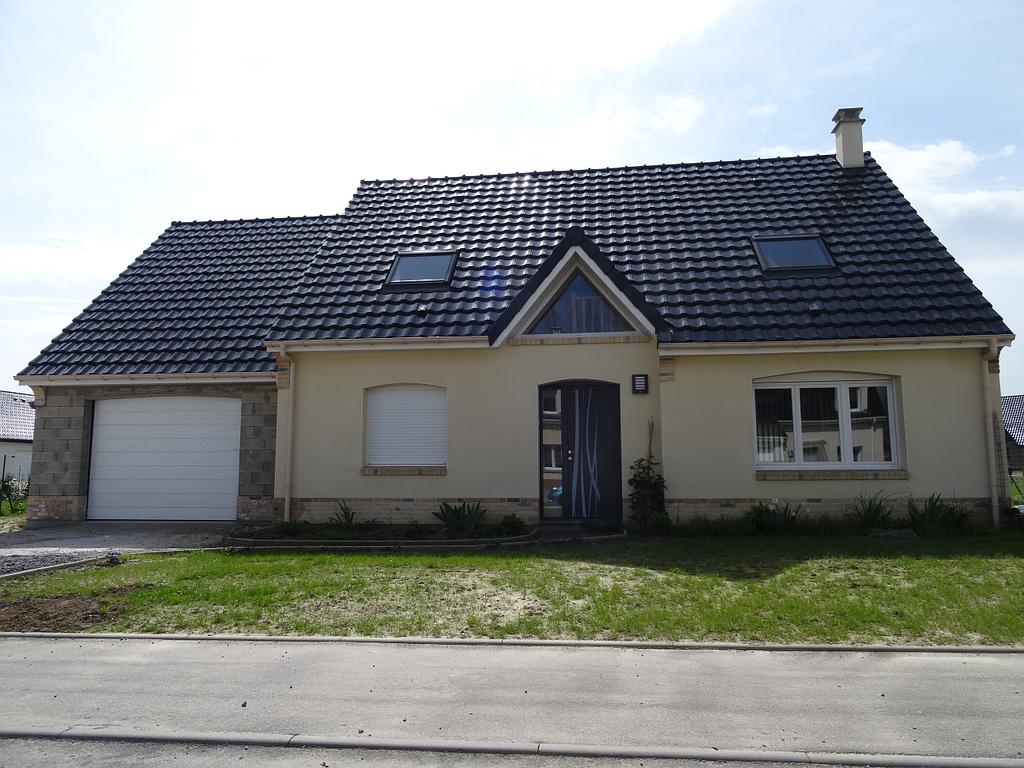 Maison neuve en crépis et briques avec toit en tuiles noires