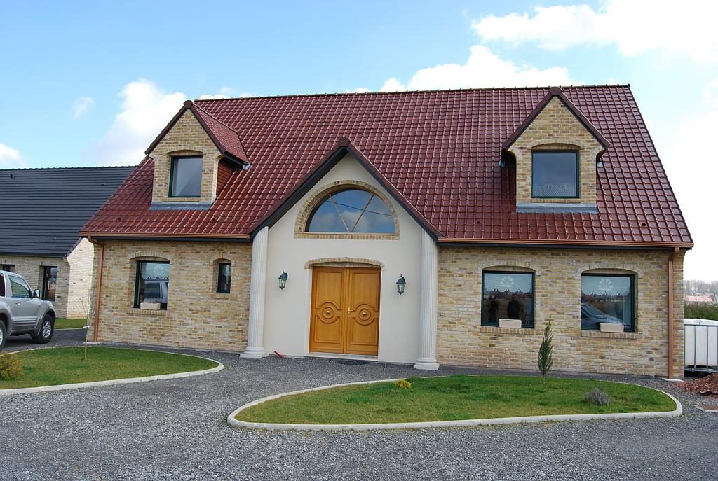 Maison individuelle de style avec porte d'entrée double en bois brute surmontée d'une fenêtre en demi-cercle