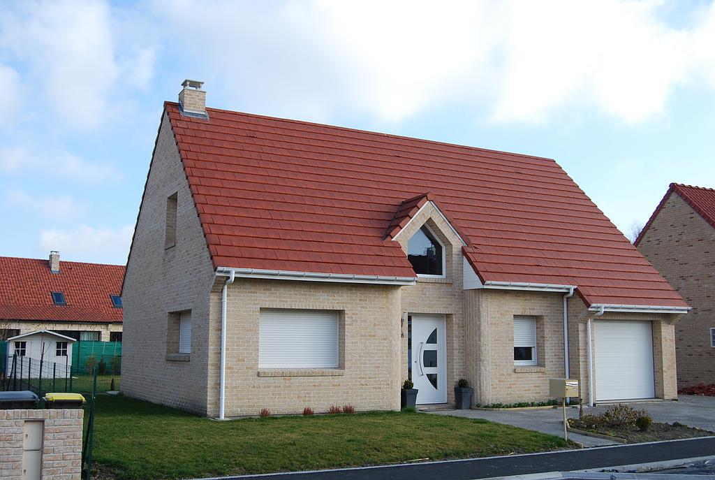 Maison individuelle avec toit en tuile rouge avec une porte d'entrée en PVC semi-vitrée