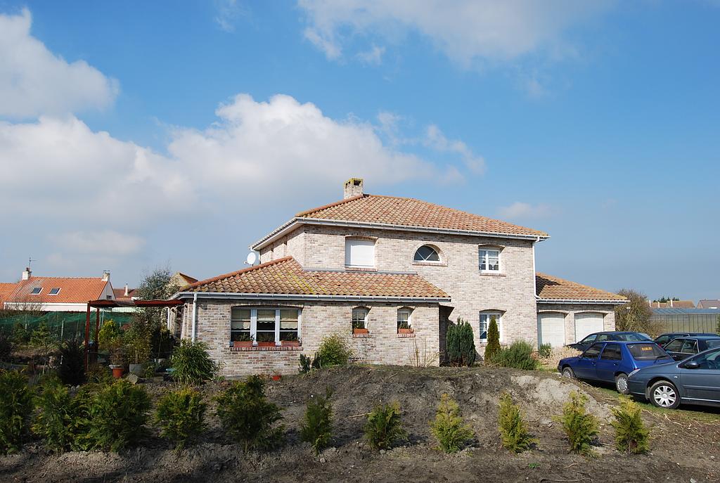 Maison individuelle sur deux niveaux avec deux garages. Le terrain avant est arboré