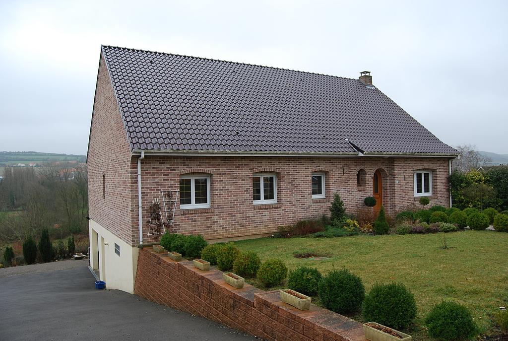 Maison individuelle dont les pièces de vie sont de plain-pied, mais le garage se trouve en sous niveau par rapport à la maison