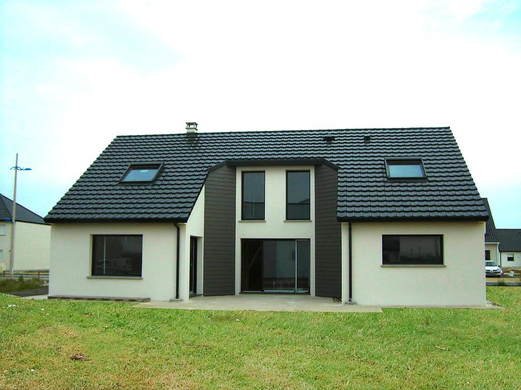 Photo d'une maison individuelle prise depuis le terrain arrière, vue sur la terrasse et la baie vitrée