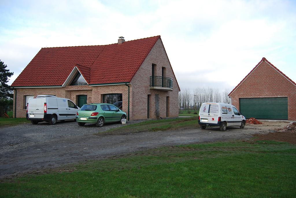 Maison indivduelle en brique rouge avec garage non attenant de la même facture