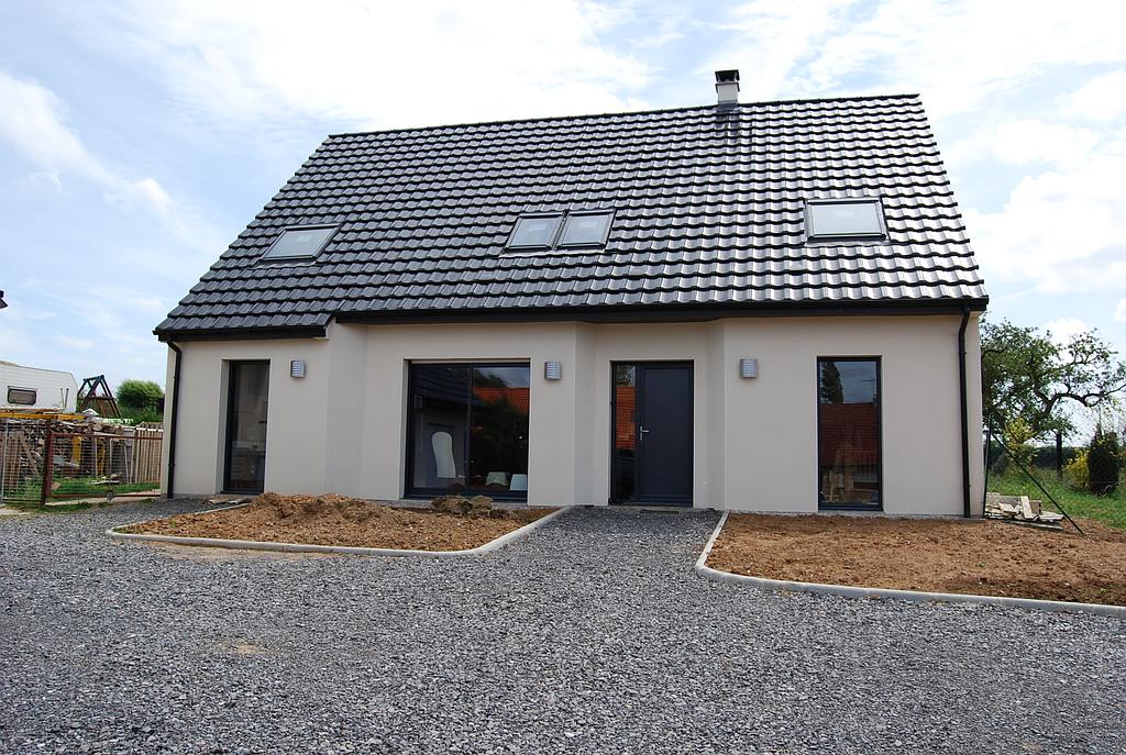 Maison à la façade blanche dont les espaces verts ne sont pas encore aménagés