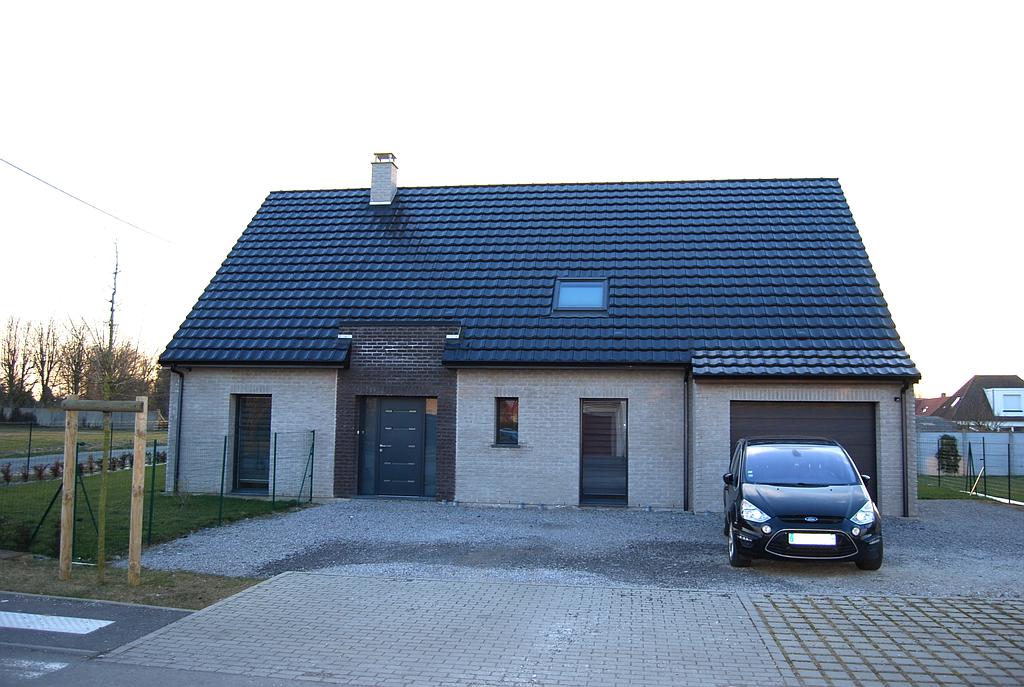 Maison individuelle avec garage. La façade est faite de briques de différents tons