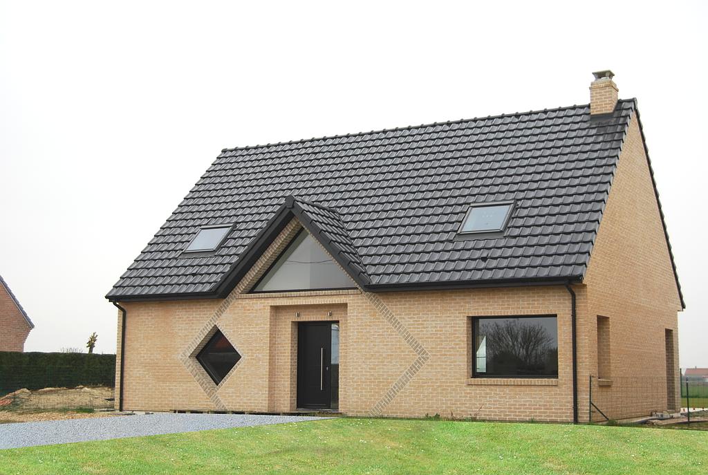 Maison individuelle de plain-pied  en brique beige et une fenêtre en losange
