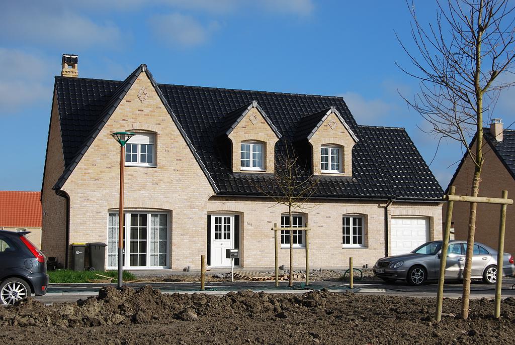 Maison individuelle sur deux niveaux, en briques blanches, dans un lotissement en cours d'aménagement