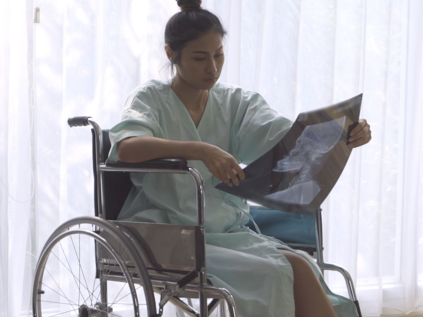 Une femme en fauteuil roulant regarde une radiographie