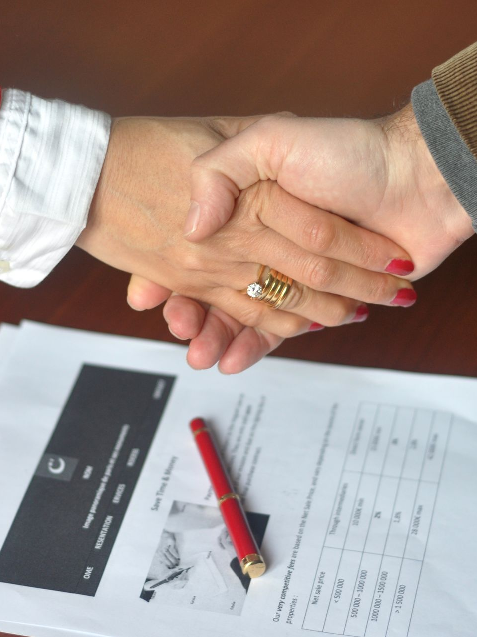 Deux personnes se serrant la main au-dessus d'un document