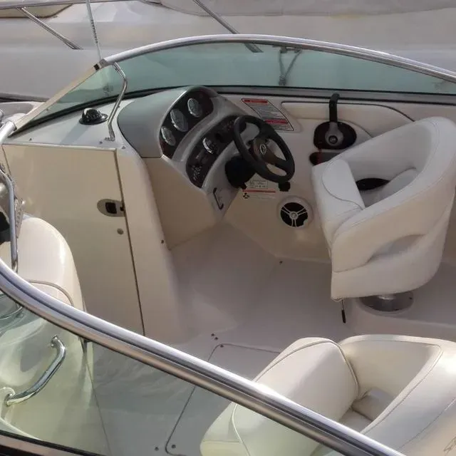 A white boat with a steering wheel and a seat