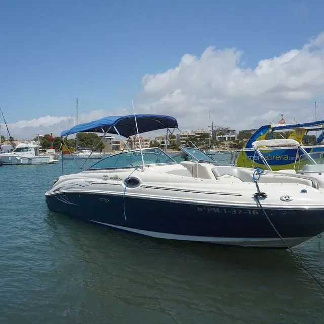 A boat with a blue canopy is docked in the water