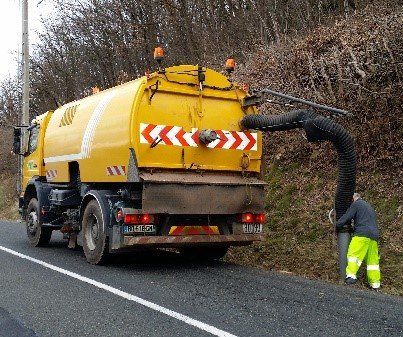 Balayeuse aspiratrice de voirie réalisant le nettoyage d'un fossé
