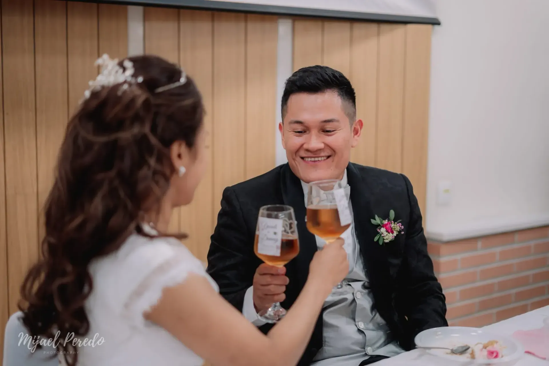 Una pareja brinda en la mesa de un restaurante, sonriendo y mirándose el uno al otro.