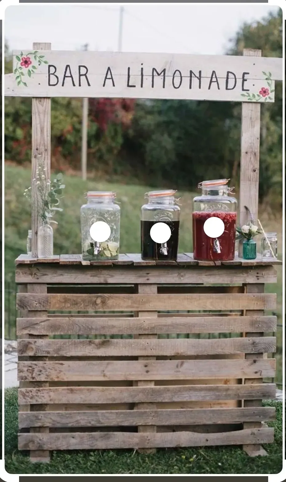 Puesto de limonada con mostrador de madera y jarras de bebidas bajo un letrero que dice