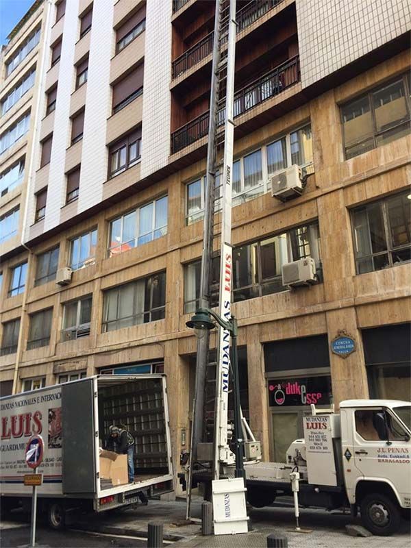 Un camión de una empresa de mudanzas está estacionado frente a un edificio.