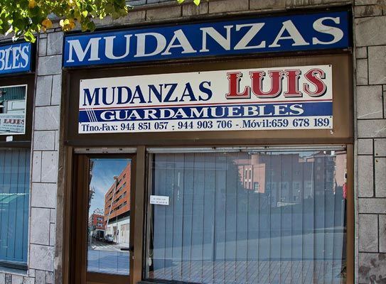 Un escaparate con un cartel que dice mudanzas luis