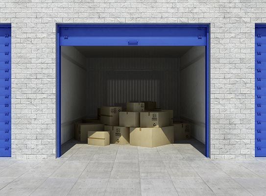 Una pila de cajas de cartón en un garaje con una puerta azul.