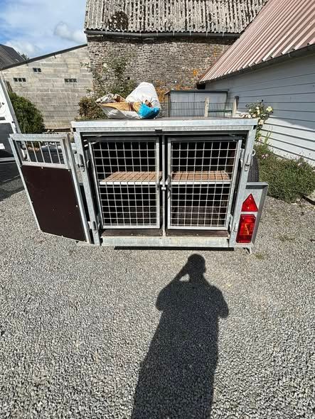 Une remorque avec quatre compartiments grillagés.