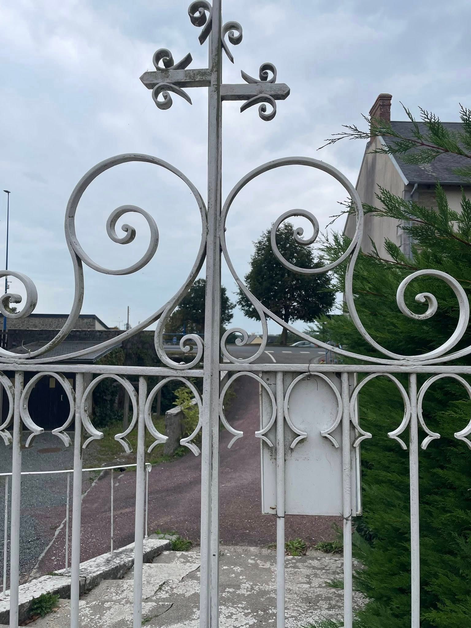 Un portail en fer forgé blanc.