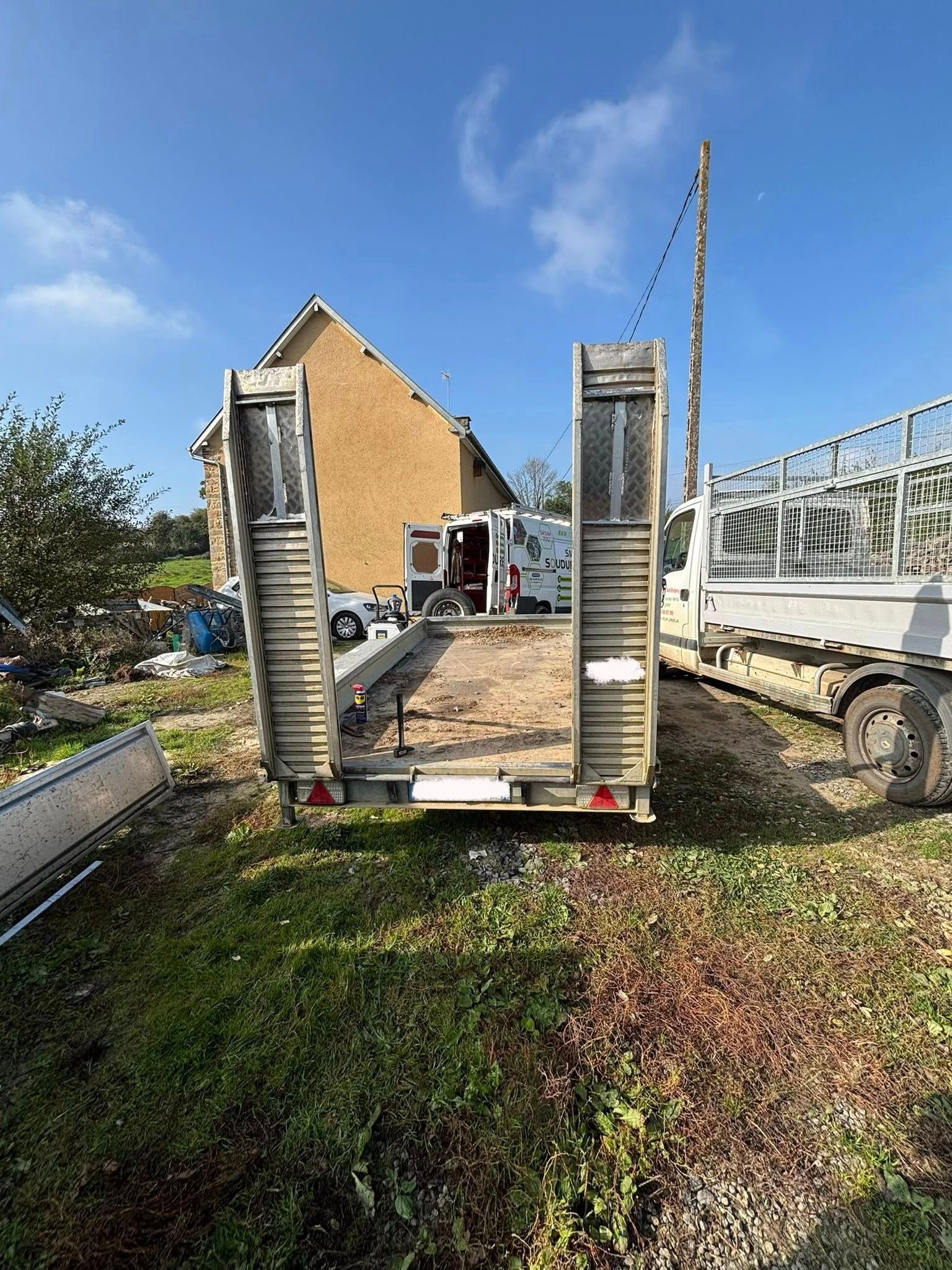 Une remorque avec ses porte-rampes, prête à charger.