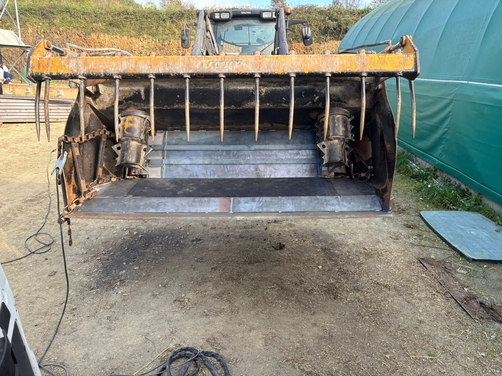 Face avant d'un grand godet fixé à un tracteur.