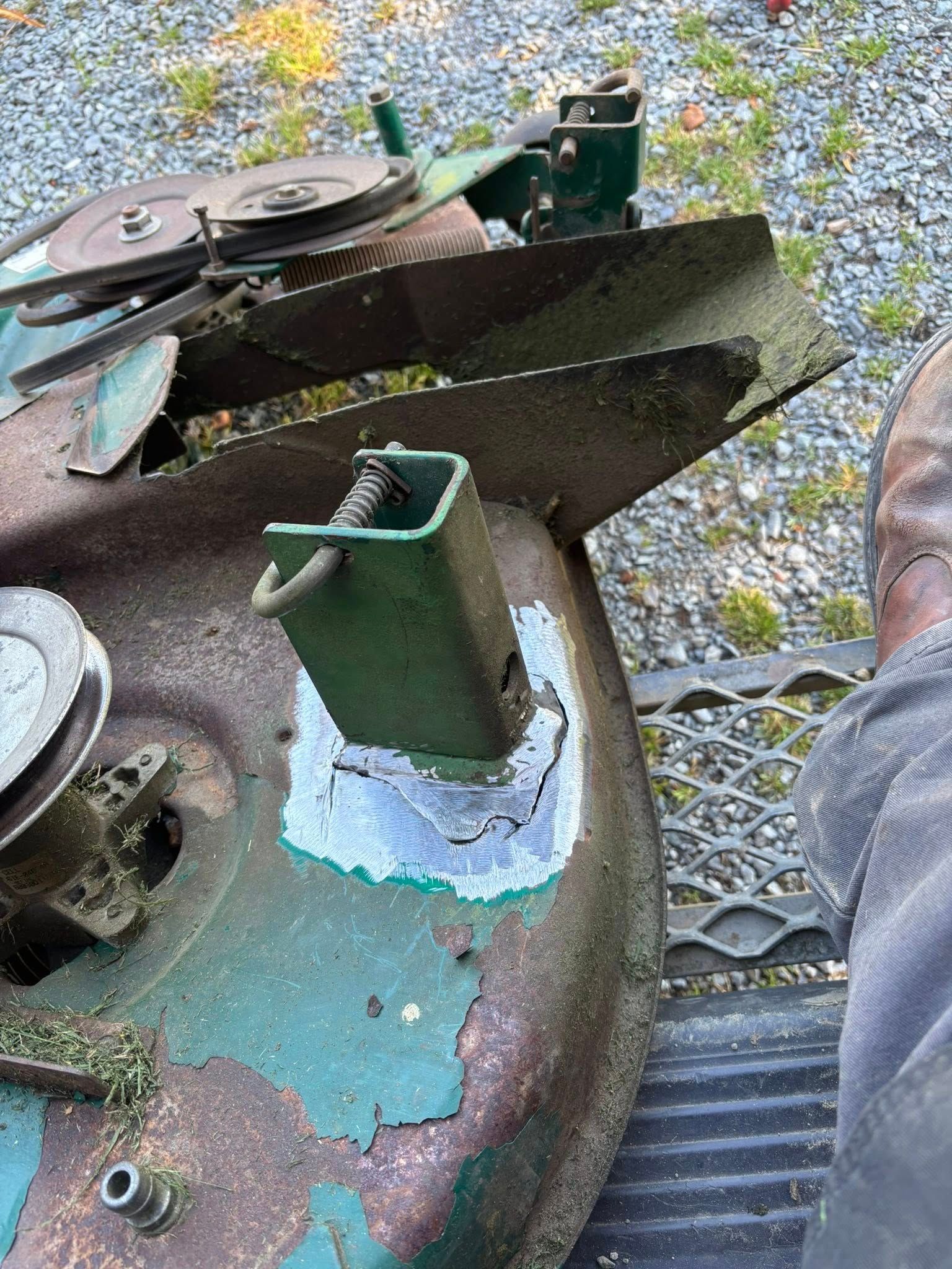 Plateau de coupe vert rouillé, lames apparentes, montrant une réparation soudée autour du support de lame.