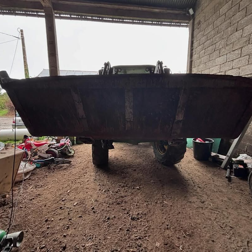 Un godet de tracteur agricole dans une grange.