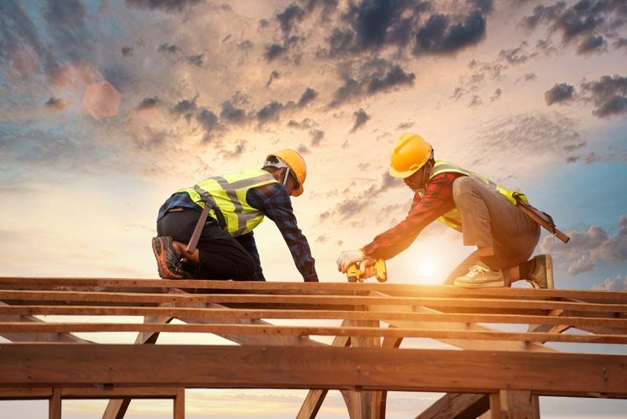 Deux artisans couvreurs qui construisent une charpente en bois