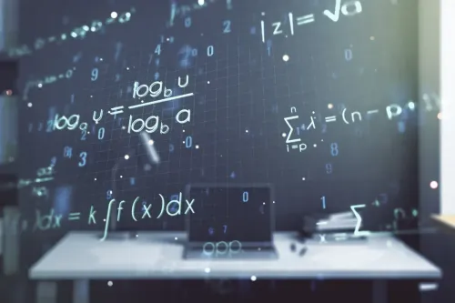 Ordenador portátil sobre un escritorio con ecuaciones matemáticas superpuestas sobre un fondo oscuro.