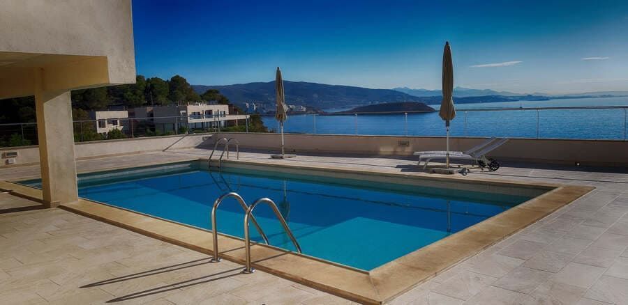 Una gran piscina con escaleras que conducen a ella con vistas al océano.