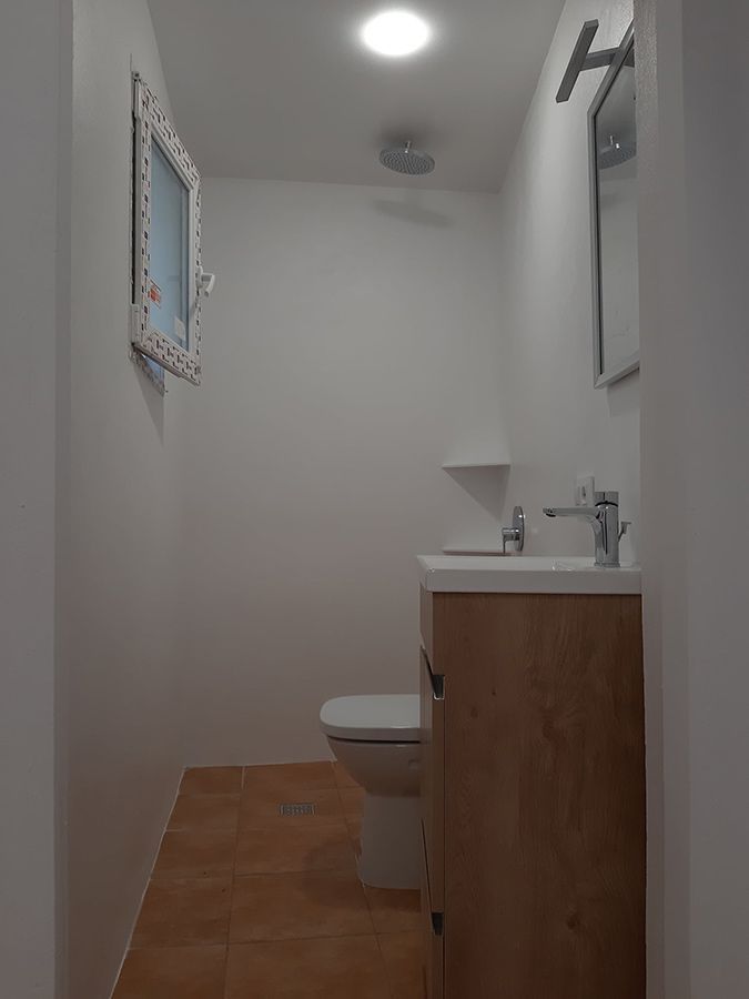 Un baño con inodoro, lavabo y espejo.