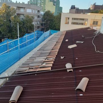 Un tejado con muchas tejas y un edificio al fondo.